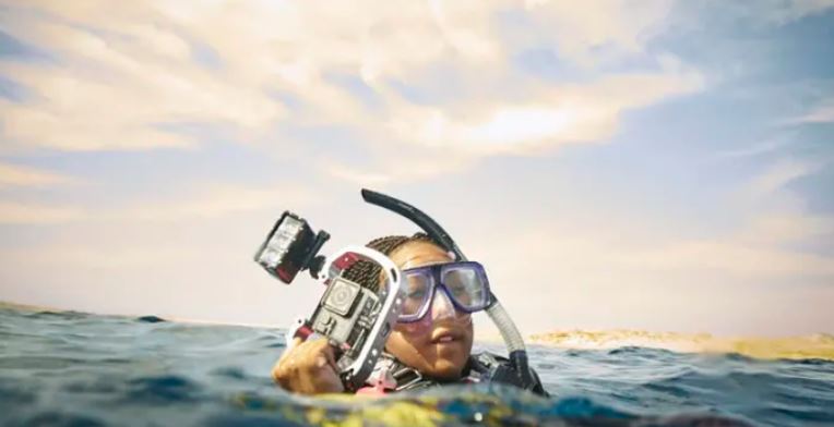 Girl snorkeling with a camera